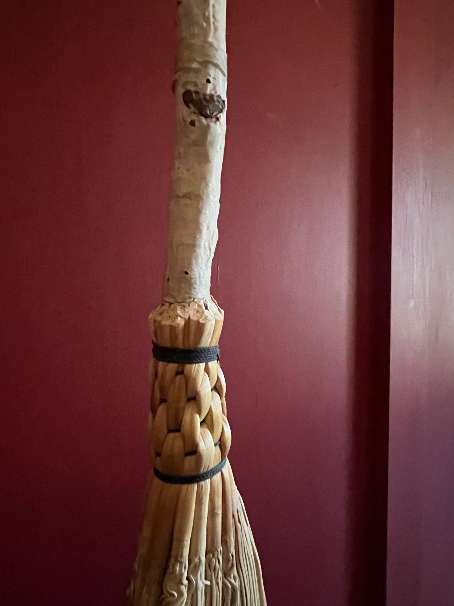 Handmade broomcorn broom on a Paper Birch tree branch broomstick