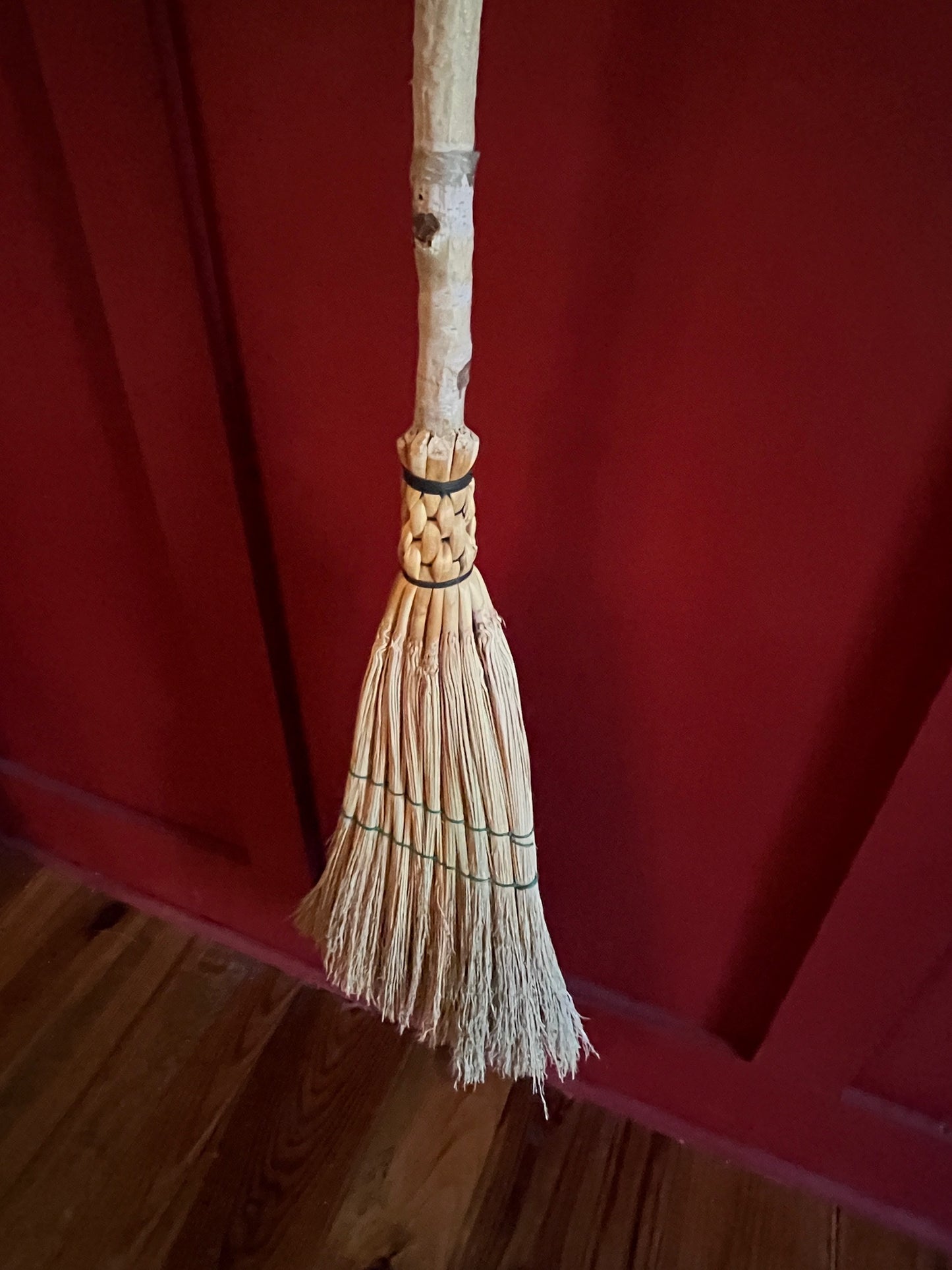 Handmade broomcorn broom on a Paper Birch tree branch broomstick
