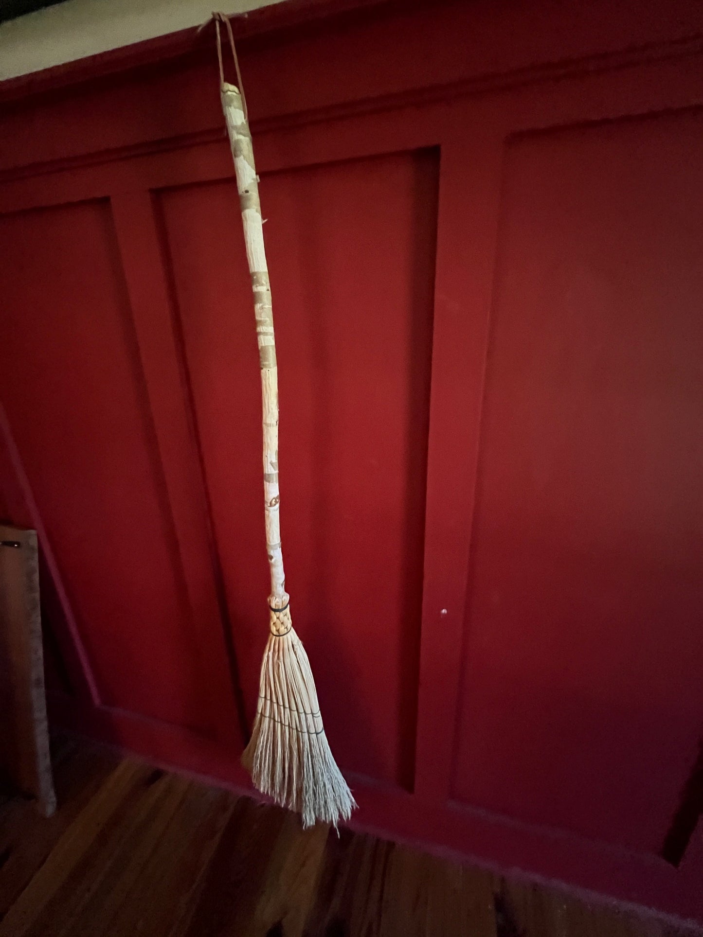 Handmade broomcorn broom on a Paper Birch tree branch broomstick