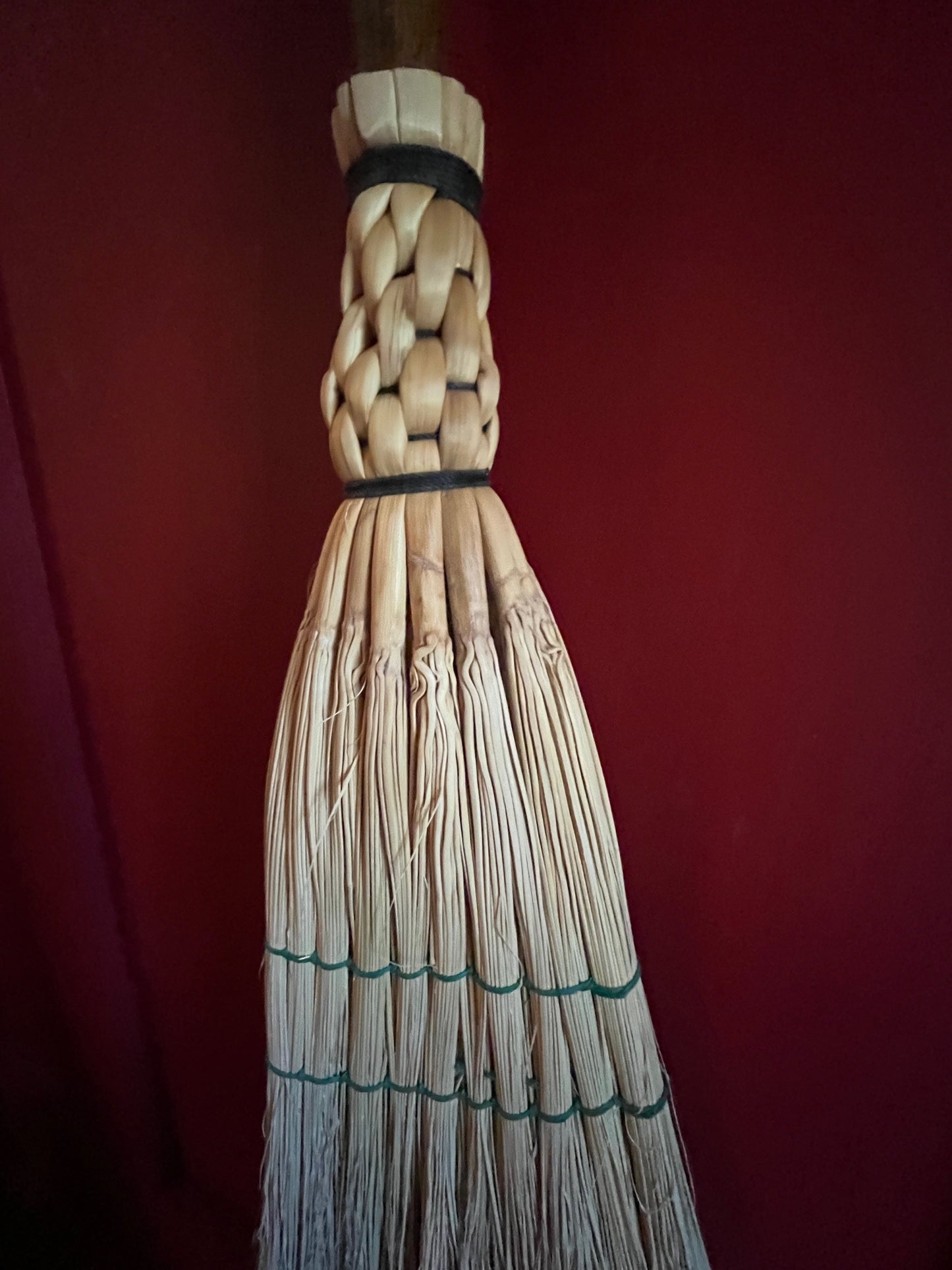 Handmade broomcorn broom on a tree branch broomstick