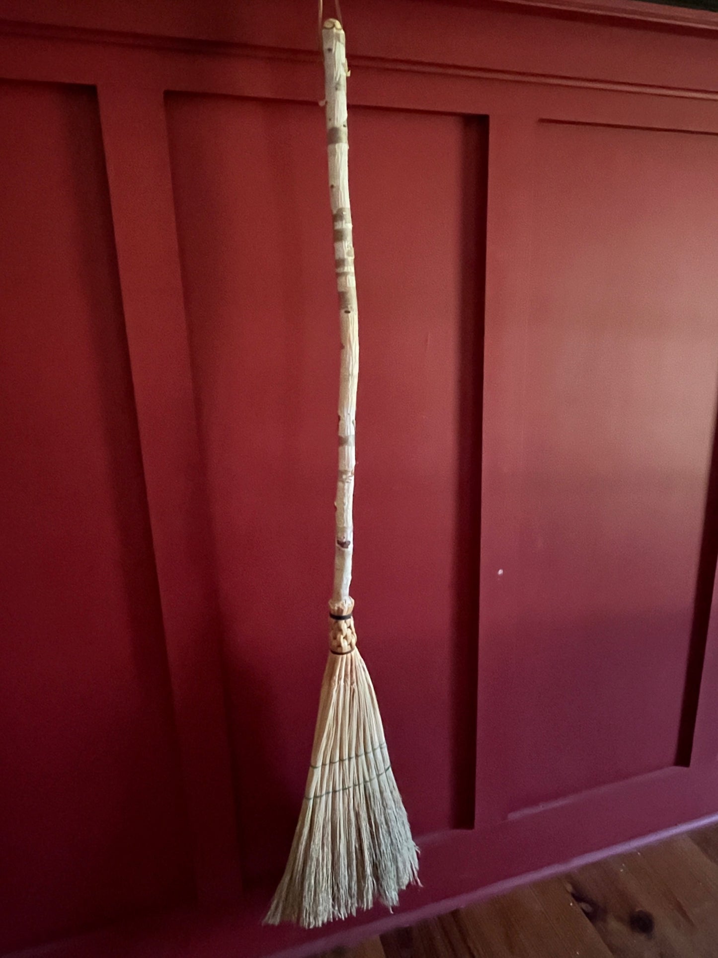 Handmade broomcorn broom on a Paper Birch tree branch broomstick